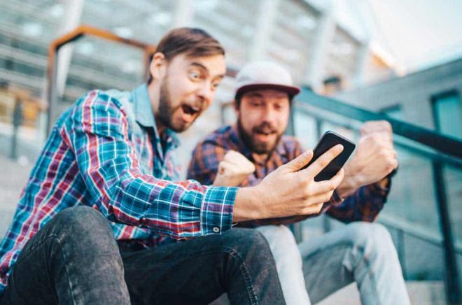 Johan och Johannes blev så här glada när Boktugg visade dem en lista på vilka uppläsare som tackat ja till Ljudboksfestivalen på Friends Arena. Foto: iStock.