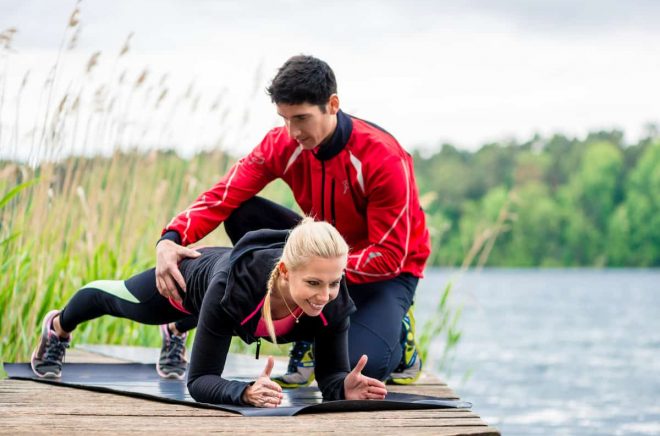 Woman with personal trainer doing fitness push-up