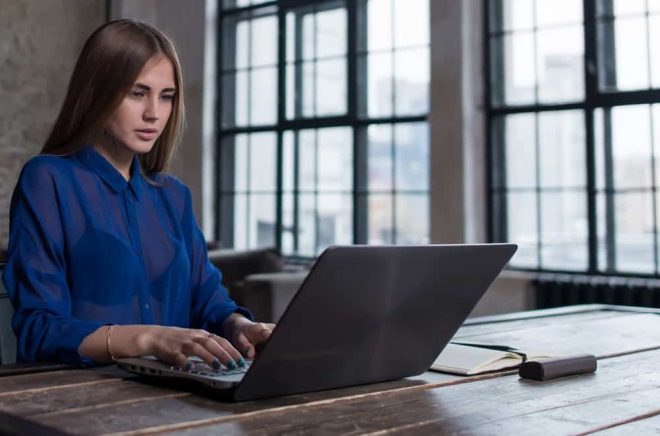 Kvinna läser ebok på laptop. Foto: Fotolia