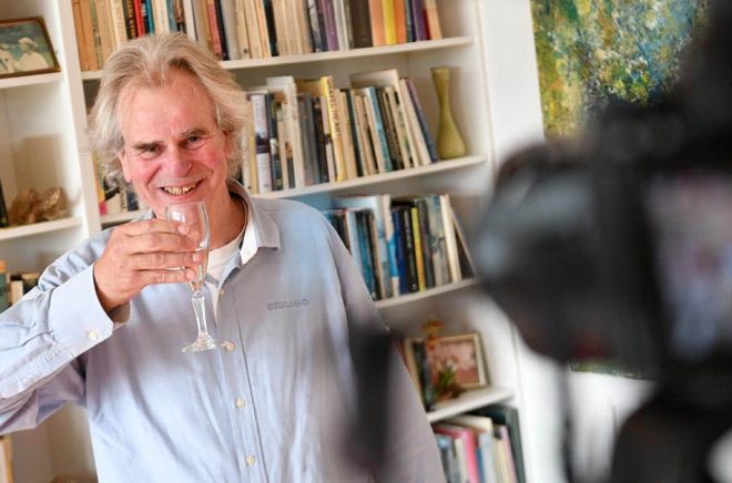 Skål för Nobelpriset! Förläggaren Henrik Celander tar emot medieuppbådet i sitt hem i Lund, där han driver förlaget Celanders, som gett ut två titlar av Abdulrazak Gurnah. Foto: Johan Nilsson/TT.