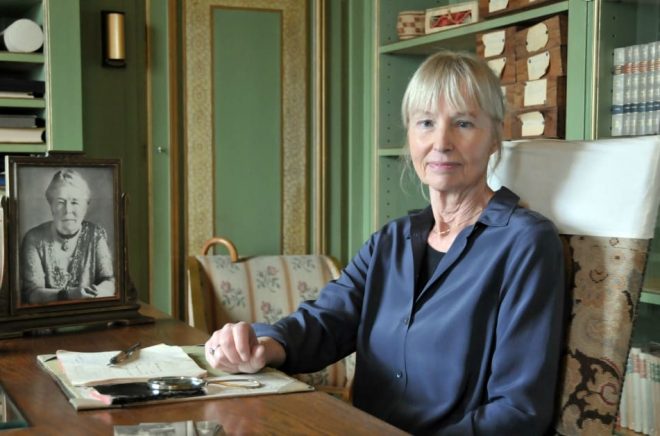 Författaren Carola Hansson vid Selma Lagerlöfs skrivbord i biblioteket på Mårbacka. Foto: Kjell Sundström