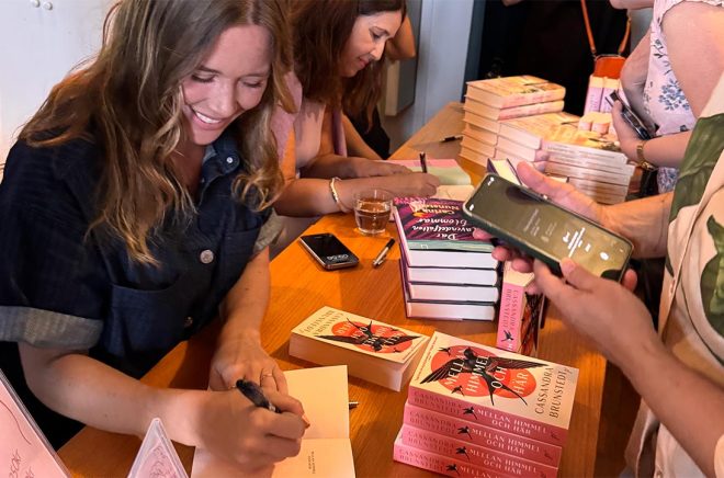 Cassandra Brunstedt signerar den nya pocketboken på Feelgoodfestivalen där hon fick ta emot priset för Årets Feelgood 2025. Pressbild.