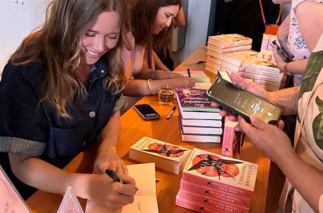 Cassandra Brunstedt signerar den nya pocketboken på Feelgoodfestivalen där hon fick ta emot priset för Årets Feelgood 2025. Pressbild.