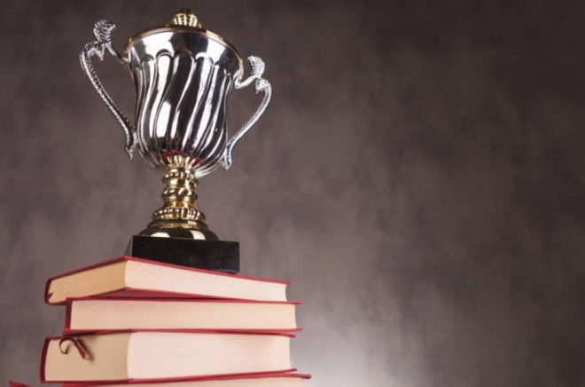 trophy cup on a pile of books with copyspace, studio picture