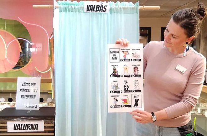 Ida Hadžić visar upp kandidaterna i Barnens val framför valbåset på Rosengårdsbiblioteket. Pressbild: Malmö Stad